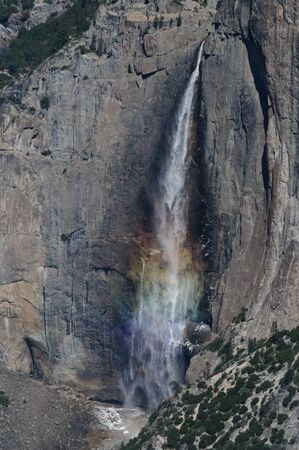 A Rainbow is cast by the Upper Yosemite Falls, as seen from Glacier Point.の写真素材