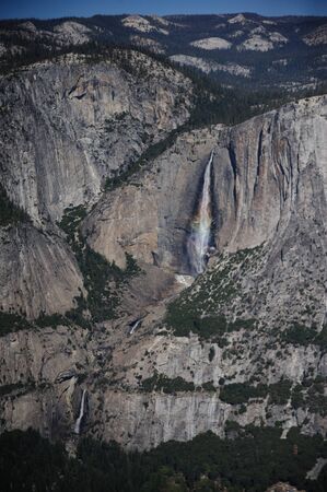 A Rainbow is cast by the Upper Yosemite Falls, as seen from Glacier Point.の写真素材