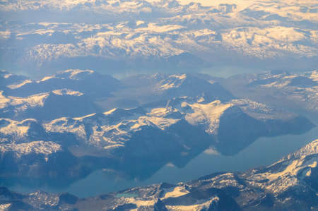 Mountains reflecting in frozen lakes near the coast of Greenland.の写真素材
