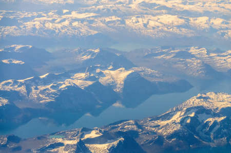 Mountains reflecting in frozen lakes near the coast of Greenland.の写真素材
