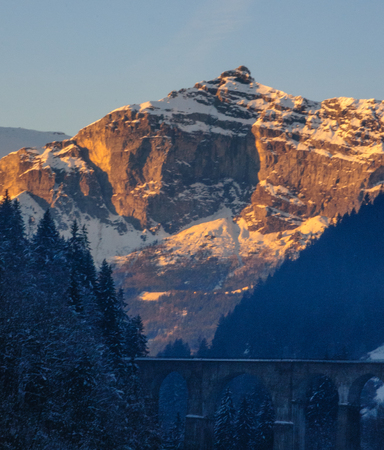 Low sun illuminatating the mountains near the  town of Chamonix-de-Mont Blanc on an early winters afternoon.の写真素材