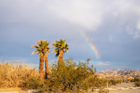 A rare sighting of a rainbow over the Furnace Creek Campground on a summer evening in Death Valley.の写真素材