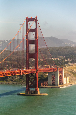Image of the Golden Gate Bridge on a Summer afternoon. A boat is sailing underneath itの写真素材