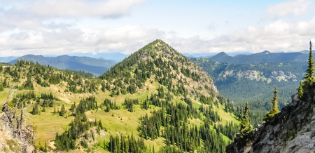 Mount Rainier peaking through the clouds and the surrounding forest.の写真素材