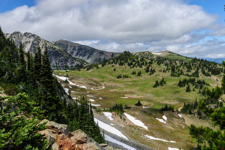 Mount Rainier peaking through the clouds and the surrounding forest.の写真素材