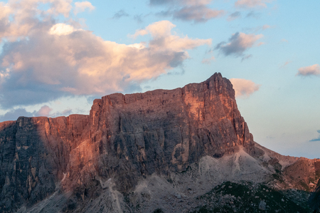 Sunset at the Passo di Giau, casting a red glow on the rugged mountains of the Italian Dolomites, on a late July evening.の写真素材