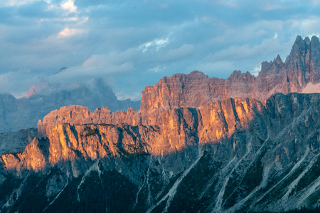 Sunset at the Passo di Giau, casting a red glow on the rugged mountains of the Italian Dolomites, on a late July evening.の写真素材