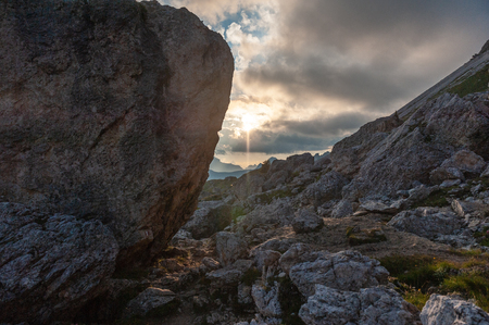Watching the Setting sun from behind a rock. Image from a sunset at the Giao Pass in the Italian Dolomites.の写真素材