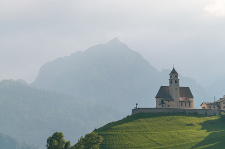 The Church in the village of Colle Santa Lucia in the Golden hours, just before sunset. Italian Dolomites on a summers evening.の写真素材