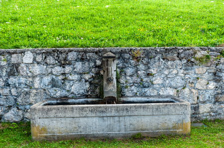 A water fountain in the village of Santa Fosca, in the Italian Dolomites on a Summer morning.の写真素材