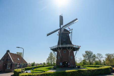 A Classic Dutch Windmill in the city of Dokkum, Friesland, in the Northern parts of the Netherlands, as seen on a bright sunny spring afternoonの写真素材