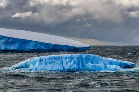 Giant icebergs floating off the Coast of Brown Bluff, the Northernmost tip of the Antarctic Peninsula. Storm Clouds are lining the Skies.の写真素材