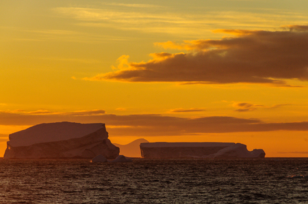 Antarctic Sunset: Floating Icebergs in the Weddell Sea, near the Antarctic Peninsula, as seen from an Antarctic Exploration Shipの写真素材