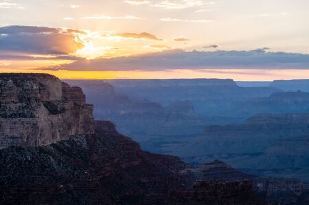 The setting sun sinking below the horizon of the Grand Canyon, near Yavapai point on the southern...