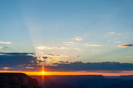 The setting sun sinking below the horizon of the Grand Canyon, near Yavapai point on the southern canyon rim.の写真素材