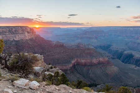 The setting sun sinking below the horizon of the Grand Canyon, near Yavapai point on the southern canyon rim.の写真素材