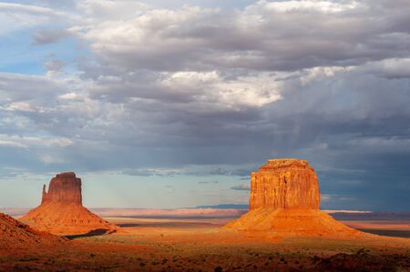 The famous Merrick and Mittens Buttes from monument valley basking in the Light of the setting sun.の写真素材
