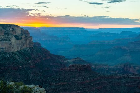 The setting sun sinking below the horizon of the Grand Canyon, near Yavapai point on the southern canyon rim.の写真素材