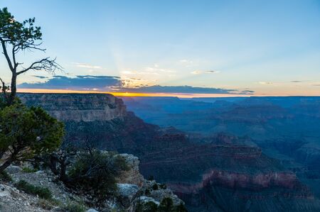 The setting sun sinking below the horizon of the Grand Canyon, near Yavapai point on the southern canyon rim.の写真素材
