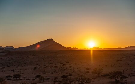The rsing sun above the desert of Namibia, near the Khomas region.の写真素材