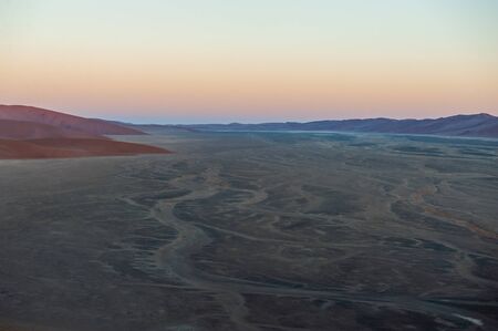 Early morning sunlight illuminating the red sand of Namibias sussusvleiの写真素材