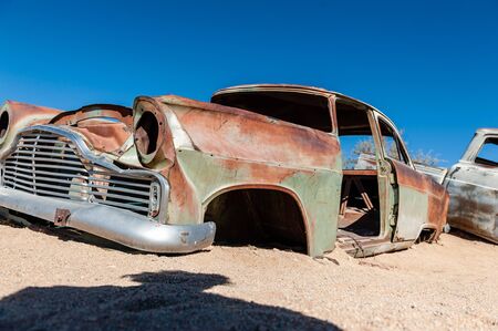 Wrecks of historic cars line the road in the town of Solitaire in the Khomas Region of Namibia.の写真素材