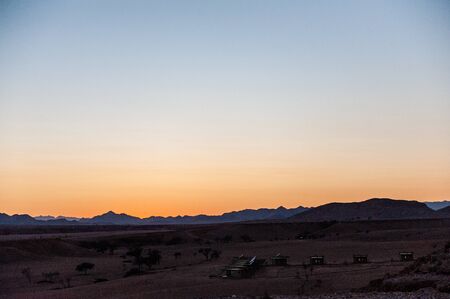 The rising sun is casting long shadows across the Dune Landscape of the Khomas Region in Central Western Namibia.の写真素材