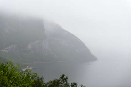Low hanging clouds contrast with mountains and lakes in northern norway.の写真素材