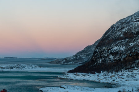 Overlooking the snow-covered beaches of arctic norway, near the town of Bodo, during the golden hour of the arctic winter.の写真素材