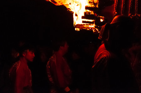 Miyajima, Japan - December 31, 2019. Participants of the Chinkasai Fire Festival at Itsukushima Shrine, near Hiroshima, carry large burning torches around the sea shore as part of a ritual to safeguard the island from fires.のeditorial素材