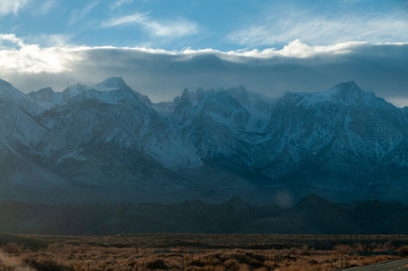 The towering mountains of the Sierra Nevada form a backdrop of the road to Lone Pine, California.の写真素材