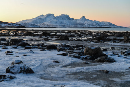 Wide angle landscape shot of the snow covered mountains and beach near Mjelle, part of the Bodo community in Arctic Norway, during the brief period of daylight in the arctic winter.の写真素材