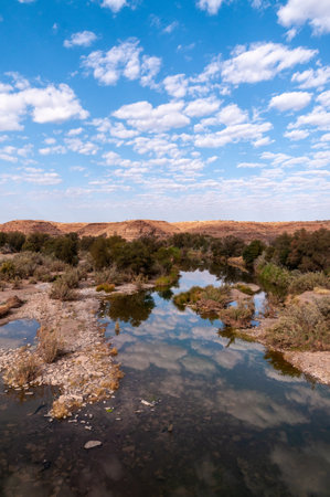 Low hanging clouds are reflected in a water of the Fish river in southern Namibia.の写真素材