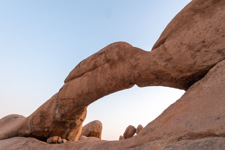 Sunset over the rock arch near Spitzkoppe, a famous granite peak in the center of namibia.の写真素材