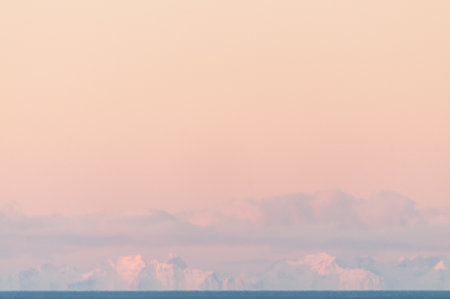 Telephoto shot of the snow-covered mountains of the Lofoten, as seen from the Norwegian mainland, near the town of Bodo.の写真素材