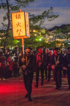 Miyajima, Japan - December 31, 2019. Participants of the Chinkasai Fire Festival at Itsukushima Shrine, near Hiroshima, carry large burning torches around the sea shore as part of a ritual to safeguard the island from fires.のeditorial素材