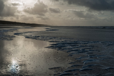 Clouds reflecting in a residu of water on the Beach near Egmond aan Zeen in North Holland, the Netherlands.の写真素材