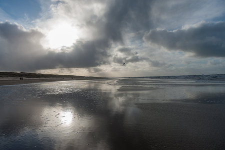 Clouds reflecting in a residu of water on the Beach near Egmond aan Zeen in North Holland, the Netherlands.の写真素材