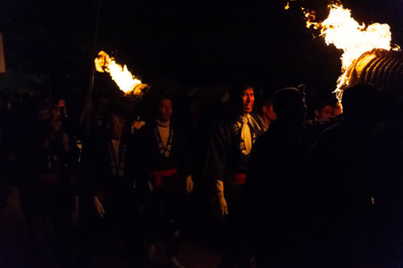Miyajima, Japan - December 31, 2019. Participants of the Chinkasai Fire Festival at Itsukushima Shrine, near Hiroshima, carry large burning torches around the sea shore as part of a ritual to safeguard the island from fires.のeditorial素材
