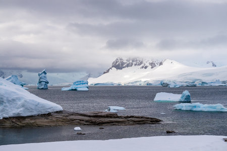 Giant iceberg and intriguinly shaped ice formation align the Coast of Charlotte Bay, as seen from Portal point.の写真素材