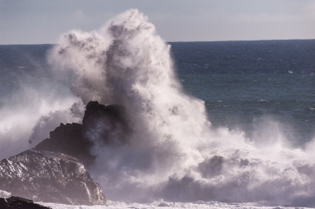 Spectacularly big waves from the pacific ocean smash into the californian coast along US highway 1.