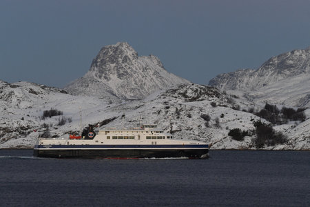 Bodo, Norway - January 4, 2023. Telephoto shot of a ferry with snow-covered mountains in the background. Ferries like these play an important role in Norways public transport system.のeditorial素材