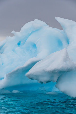 Detail of a patch of Antarctic sea ice, containing wonderous shapes and deep blue colours.