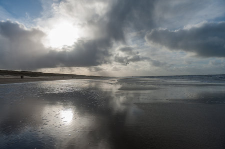 Clouds reflecting in a residu of water on the Beach near Egmond aan Zeen in North Holland, the Netherlands.の写真素材