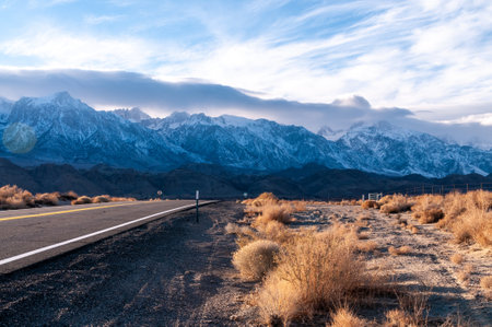 The towering mountains of the Sierra Nevada form a backdrop of the road to Lone Pine, California.