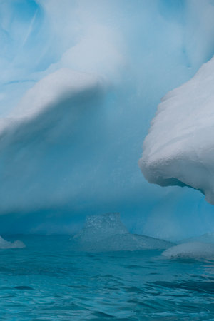 Detail of a patch of Antarctic sea ice, containing wonderous shapes and deep blue colours.