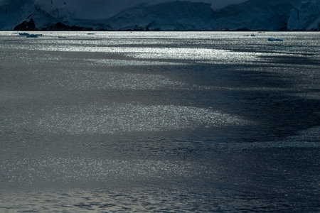 Backlit image of a tranquil sea near Graham Passage, Antarctic Peninsulaの写真素材