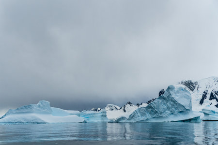 An Antarctic landscape shot near Cuverville island, highlighting mountains and icebergs.の写真素材