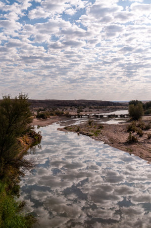 Low hanging clouds are reflected in a water of the Fish river in southern Namibia.の写真素材