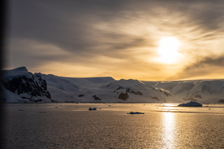 Icebergs and Glaciers align the coast of the Antarctic peninsula, and its many islands. Image taken during the golden hour after sunrise in the Gerlache straitの写真素材